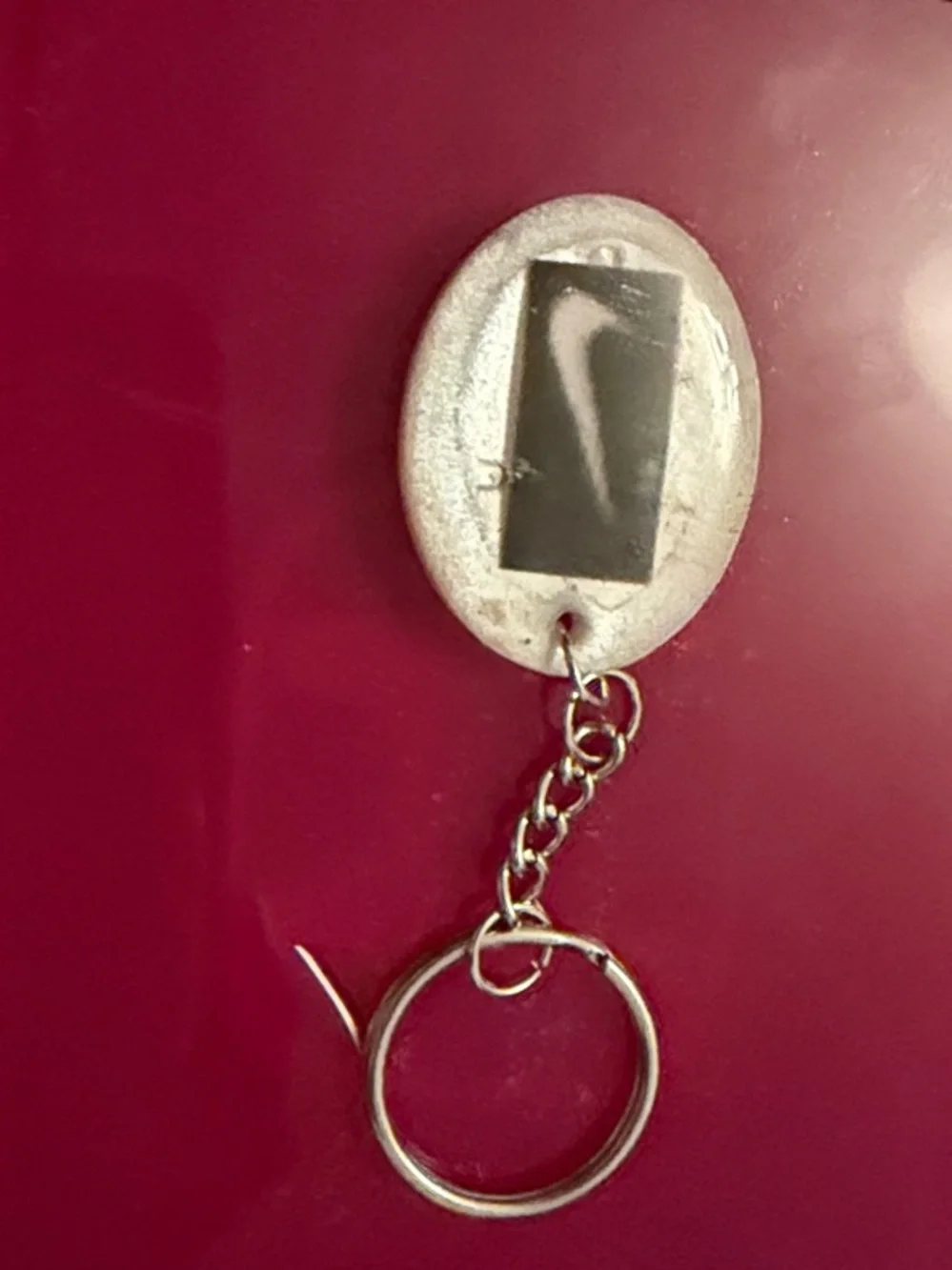 Silver Oval Keychain on Maroon Background